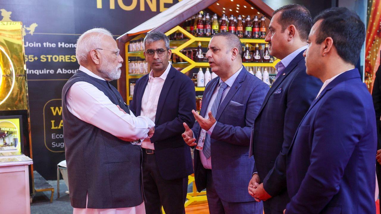Prime Minister Narendra Modi interacts with a businessman at the exhibition during International Trade Show